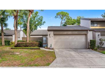 Charming townhouse with a one-car garage and a well-maintained front yard with a privacy hedge at 411 Meadowood Blvd, Fern Park, FL 32730