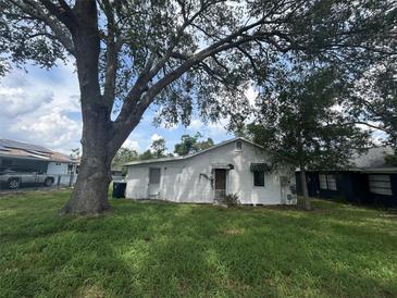 A view of the backyard and the back of the house featuring a large tree at 509 Lemon St, Auburndale, FL 33823