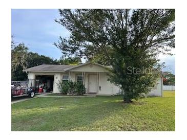 Charming single-story home featuring a cozy front yard and a convenient attached garage at 104 Corena Ct, Kissimmee, FL 34743