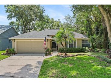 Charming single-story home with an attached garage, well-maintained lawn and appealing landscaping features at 1354 Dutch Elm Dr, Altamonte Springs, FL 32714