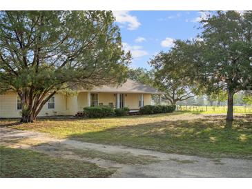 Charming home featuring a well-manicured lawn and mature trees, offering a serene and inviting curb appeal at 16017 Johns Lake Rd, Clermont, FL 34711