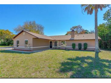Charming single-story home with a well-manicured lawn and mature landscaping, creating excellent curb appeal at 1842 Evergreen Dr, Edgewater, FL 32141