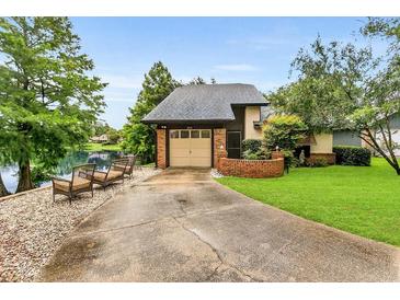 Charming home with a well-maintained front yard and cozy seating overlooking the adjacent lake at 3501 Danby Ct, Orlando, FL 32812