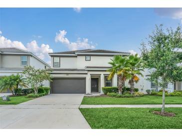 Two-story home with a two-car garage, tidy landscaping, and well-maintained lawn at 518 Marcello Blvd, Kissimmee, FL 34746