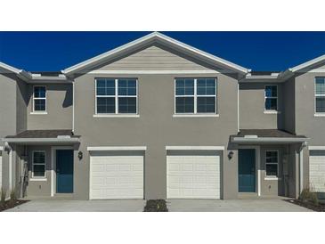 Charming townhome featuring a two-car garage and well-maintained gray facade at 6611 Leo Ln, St Cloud, FL 34773