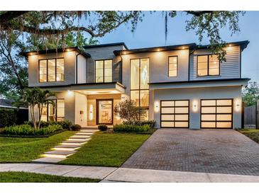Modern two-story home with a manicured lawn, stone walkway with lights, and a two-car garage at 1211 Munster St, Orlando, FL 32803