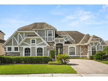 Charming two-story home showcasing a blend of stone and siding accents and a well-manicured lawn at 16108 Bristol Lake Cir, Orlando, FL 32828