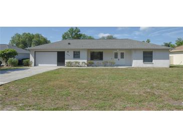 Charming single-story home with a well-manicured lawn and attached one car garage at 1668 Fort Smith Blvd, Deltona, FL 32725