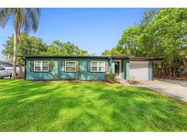 Welcoming home featuring a freshly painted exterior, an attached garage, and lush green lawn at 1805 Paloma Ave, Sanford, FL 32771