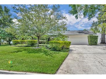 Charming single-story home with a well-manicured lawn, mature trees, and a two-car garage at 2081 Mohican Trl, Maitland, FL 32751