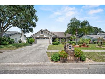 Charming single-story home with a well-manicured lawn, mature trees, and a two-car garage on a sunny day at 2209 Fairglenn Way, Winter Park, FL 32792