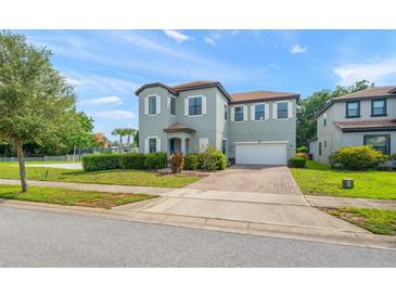 Charming two-story home with a brick driveway, two-car garage and well-manicured lawn at 235 Aidans Lndg, Haines City, FL 33844