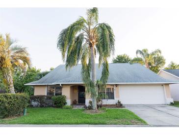 Charming single-story home with a well-manicured lawn and a grand palm tree in the front yard at 596 Starstone Dr, Lake Mary, FL 32746