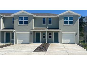 Two-story townhome featuring a one-car garage and manicured landscaping at 6627 Leo Ln, St Cloud, FL 34773