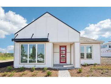 Modern home featuring a crisp white exterior, black awning, and a vibrant red front door at 6723 Sherpa Trl, St Cloud, FL 34771