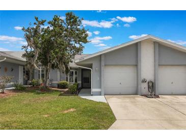 Charming single-story home featuring a well-maintained lawn, covered entry and attached two-car garage at 10438 Sw 85Th Ct, Ocala, FL 34481