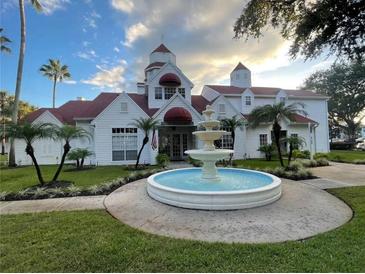 Attractive two-story building with red awnings, lush landscaping, and a charming fountain at 11582 Westwood Blvd # 1428, Orlando, FL 32821