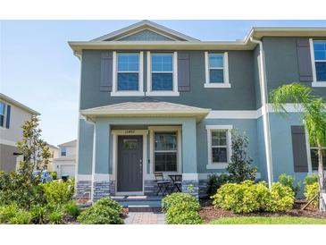 Charming two-story townhome with covered porch and well-maintained landscaping, providing excellent curb appeal at 13452 Sagestone Dr, Winter Garden, FL 34787