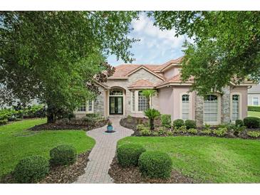 Charming home featuring a brick walkway, stone accents, well-maintained lawn, and mature landscaping at 1453 Langham Ter, Lake Mary, FL 32746