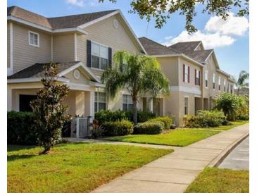 A row of townhomes with well-maintained lawns, sidewalks, and landscaping creates an inviting community feel at 2545 Old Kent Cir, Kissimmee, FL 34758