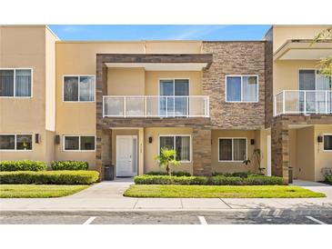 Beautiful two-story townhome features a private balcony, stone accents, and manicured landscaping at 3149 Brasilia Ave, Kissimmee, FL 34747