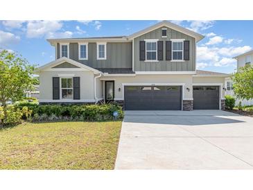 Charming two-story home with a three-car garage, manicured lawn and neutral-toned exterior at 31792 Broadwater Ave, Leesburg, FL 34748