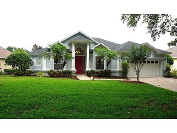 Charming single-Gathering home with a well-manicured lawn, beautiful landscaping, and a striking red front door at 8025 Old Town Dr, Orlando, FL 32819