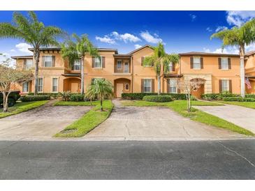 Attractive townhouses boast tropical landscaping, palm trees, brick driveways, and colorful exteriors at 936 Calabria Ave, Davenport, FL 33897