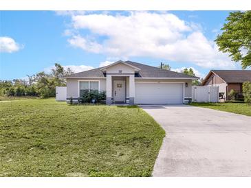 Charming single-story home with a well-maintained lawn, gray color scheme and attached two-car garage at 999 Trumbull St, Deltona, FL 32725