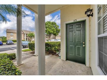 Inviting condo front door with classic design elements and number, framed by columns and lush landscaping at 141 Reserve Cir # 113, Oviedo, FL 32765