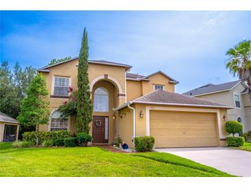 Charming two-story home featuring lush landscaping, arched entry and attached two car garage at 1933 Darlin Cir, Orlando, FL 32820