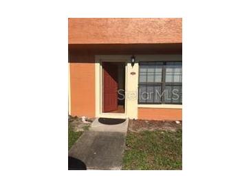 Inviting front entrance with a red door and well-maintained walkway offers a warm welcome to the home at 3318 Amber Wood Way # 100, Winter Park, FL 32792