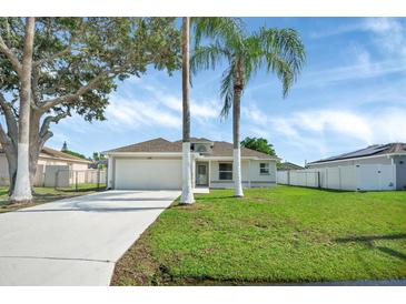 Well-maintained single-story home with lush lawn and two palm trees in front yard at 340 Edgewood Ct, Kissimmee, FL 34759