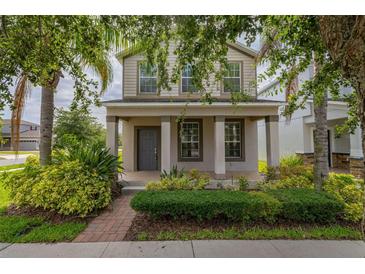 Charming two-story home featuring a welcoming front porch, well-maintained landscaping, and inviting curb appeal at 5911 Grassy Point Rd, Winter Garden, FL 34787
