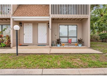 Two-story townhouse exterior with neutral siding, a walkway, and an area for plants at 752 Howland Ln # 114, Altamonte Springs, FL 32701