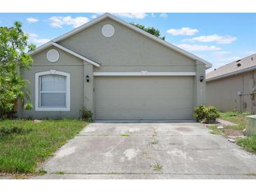 Home exterior with attached two car garage and concrete driveway at 8141 Golden Chickasaw Cir, Orlando, FL 32825