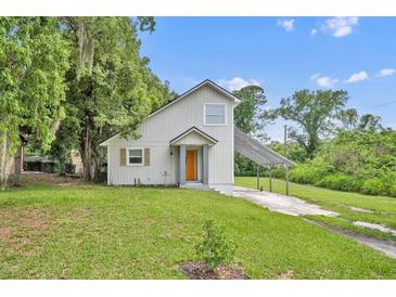 Charming home with an orange front door, neutral siding, and a covered carport at 1161 Dot Dr, Altamonte Springs, FL 32714