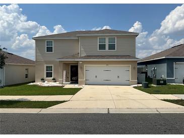 Charming two-story home with a well-manicured lawn and a welcoming front entrance at 1193 Catskill Dr, Haines City, FL 33844