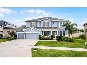 Beautiful two-story home featuring a three car garage, well-manicured lawn and lovely landscaping at 13194 Magnolia Valley Dr, Clermont, FL 34711
