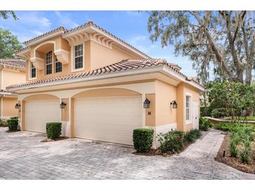 Charming home exterior with two-car garage and well-maintained landscaping at 14 Camino Real Blvd # 14, Howey In The Hills, FL 34737