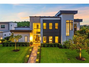 Contemporary two-story home with modern architecture, professional landscaping, and a brick walkway at 14106 Eliot Ave, Orlando, FL 32827