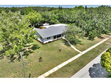 Charming single-story home with a metal roof and a well-maintained lawn at 1510 Live Oak St, New Smyrna Beach, FL 32168