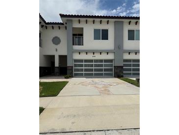 Modern townhome with a two-car garage and well-maintained landscaping at 2041 Greenbriar Ter, Davenport, FL 33837