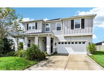 Charming two-story home features a two-car garage, well-manicured lawn, and covered front porch at 2215 Upland Ln, Apopka, FL 32712