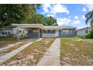 Charming single-story home with a carport and a white picket fence, showcasing its welcoming curb appeal at 2307 Freemason St, Lakeland, FL 33801