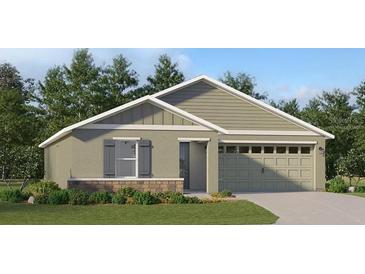 Charming single-story home with a two-car garage, manicured lawn, and craftsman-style details at 3946 Bigarade Ln, Lake Alfred, FL 33850