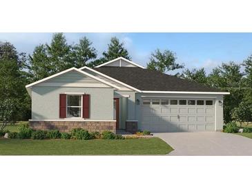 Charming single-story home with a two-car garage, a combination brick and siding facade, and manicured landscaping at 3958 Bigarade Ln, Lake Alfred, FL 33850