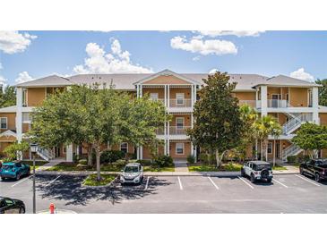 Condo building with parking lot, trees, and multiple balconies at 515 Rum Run # 33515, Davenport, FL 33897