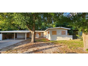 Quaint one-story home featuring a covered carport and a spacious yard, ideal for outdoor activities at 6113 Hialeah St, Orlando, FL 32808