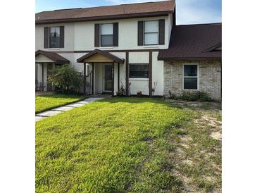Charming townhouse featuring a well-manicured lawn and a welcoming covered entryway at 9471 Comeau St, Gotha, FL 34734